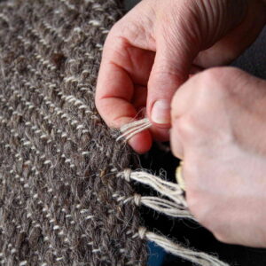 Finishing hand-woven blankets by making tassels